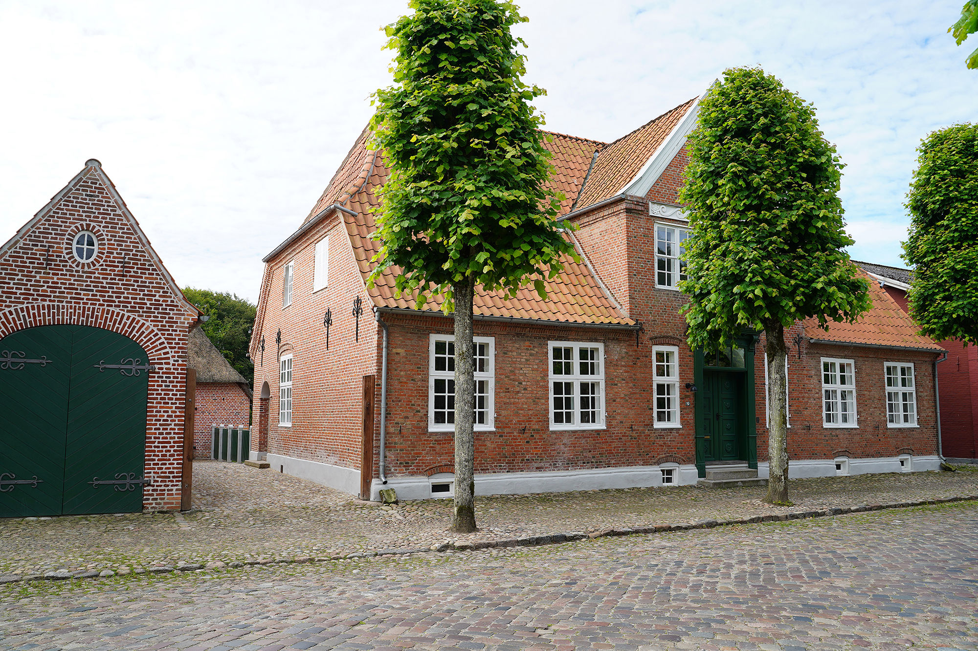 Rødt hus på en gade med brosten